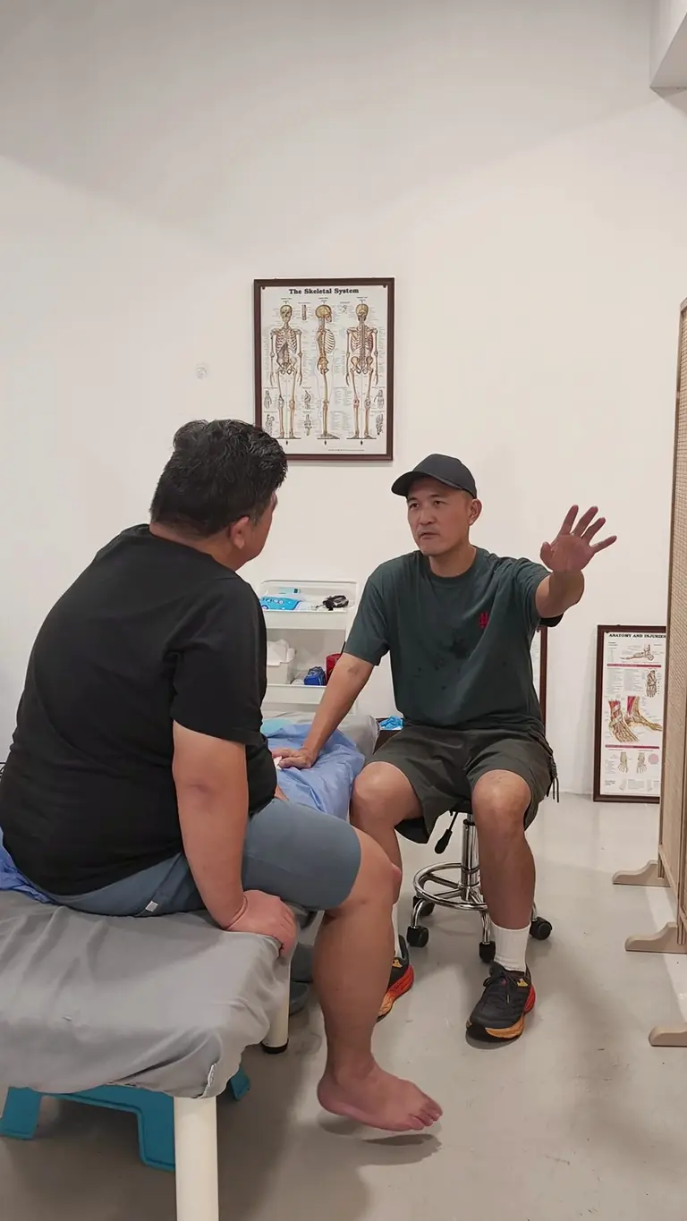 Winston discussing movement and symptoms with a patient during an Armos Therapy session